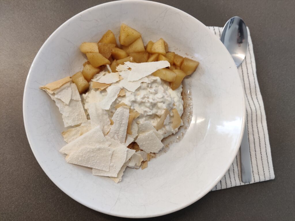 Eine Schale mit Müsli, gedünsteten Apfelstücken und knusprigen Strudelteigstücken